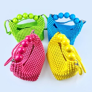 Detail of four colorful handmade beaded handbags with large beads and silver chain straps