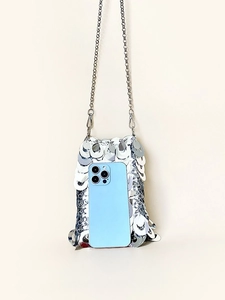 Sparkling silver sequin mini crossbody bag with chain strap and blue smartphone for scale