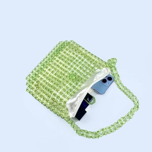 Detailed interior of green beaded bag showing satin lining and daily essentials capacity