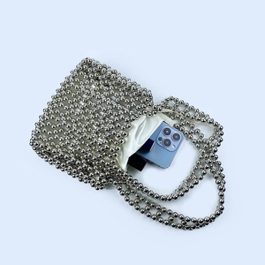 Detailed top view of silver beaded handbag showing capacity for a smartphone