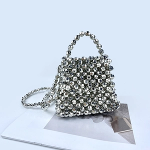 Detailed close-up of handmade silver beaded handbag with faceted metallic beads