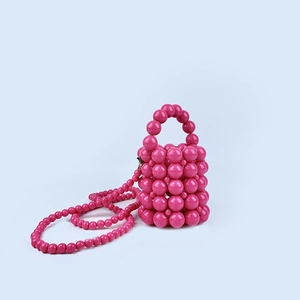 Detailed view of handmade hot pink beaded mini bucket bag with glossy resin pearls