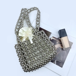 Detail of silver beaded handbag showing metallic texture and satin drawstring lining