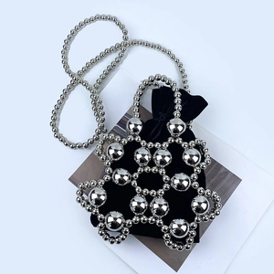 Detail of silver beaded handbag with black velvet drawstring pouch and chain strap