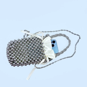 Detailed top view of silver sequin beaded bag with drawstring lining and a smartphone inside