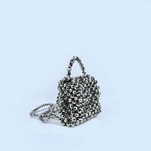 Close-up of the geometric beaded texture on the silver metallic crossbody handbag