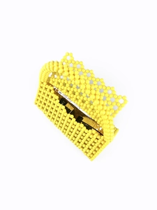 Detail of yellow handmade beaded handbag showing interior storage for phone and lipstick