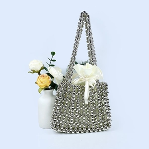 Detail of silver beaded handbag with satin drawstring lining and elegant bow tie feature