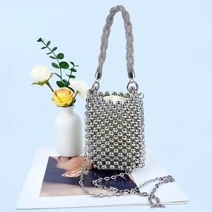 Detail of silver beaded bucket bag with sparkling finish and thick woven handle