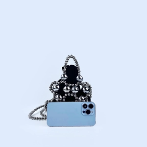 Close-up of black velvet mini bag with silver metallic beaded mesh and chain strap