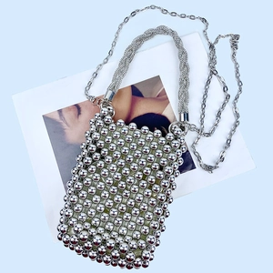 Detail of sparkly silver beaded mini handbag with rhinestone handle and metal chain