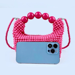 Size reference of handmade rose red beaded bag compared with a smartphone