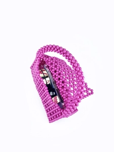 Detailed view of handmade purple beaded handbag showing capacity for phone and mirror