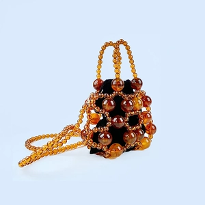 Amber beaded bucket bag with drawstring liner and acrylic bubble beads on blue background