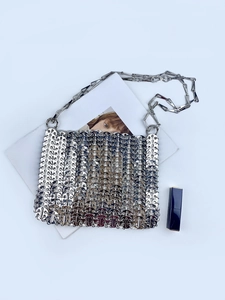 Close-up of silver metal paillette evening bag with chain strap and scale texture