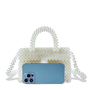 Detail of white handmade beaded pearl handbag with matching chain and phone for scale