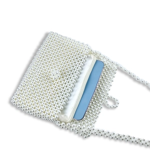 Detail showing cream beaded mini bag interior fitting a large smartphone for size
