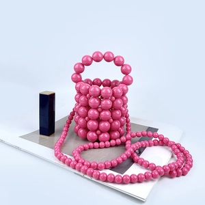 Detail of pink beaded mini bucket bag with glossy acrylic pearls and a matching shoulder strap