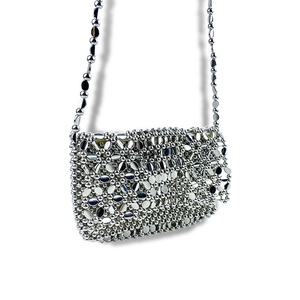 Detailed close-up of the silver metallic disc chainmail weave on a designer shoulder bag