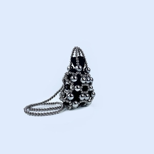 Detailed view of silver metallic beaded handbag with black velvet drawstring interior lining