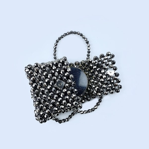 Close-up of handmade dark grey beaded handbag featuring a metallic finish and magnetic clasp