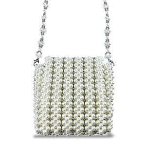 Détail d'un sac bandoulière en perles blanches tissé main avec textures perlées argent