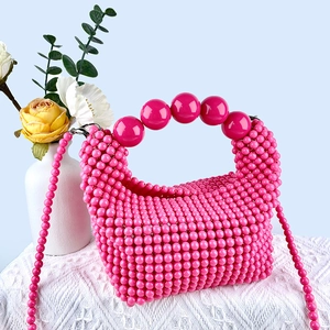 Detail of hot pink handmade beaded handbag featuring large sphere beads handle and strap