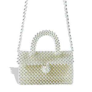 Detail of handmade cream pearl beaded crossbody bag featuring high-luster texture