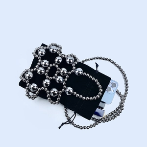 Detail of black velvet beaded bag showing silver flower pattern and interior storage