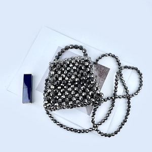 Detailed view of silver faceted bead weaving on a metallic texture handmade crossbody bag