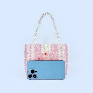 Détail du sac artisanal en perles acryliques avec motifs floraux et anse perle