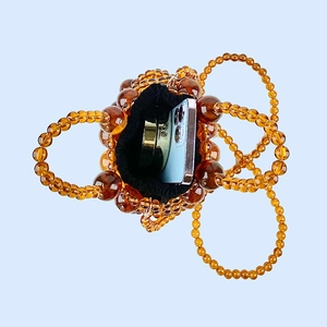 Detailed top view of amber beaded bucket bag showing inner drawstring pouch and capacity