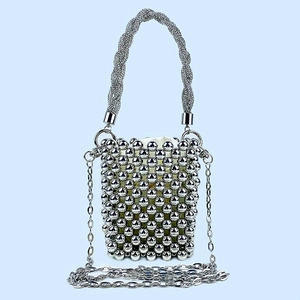Detail of silver beaded bucket bag with glitter handle and woven metallic bead texture