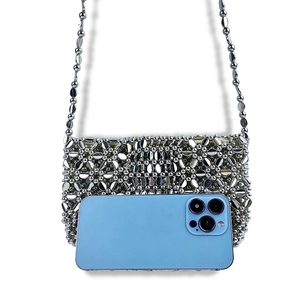 Detailed size reference of silver beaded shoulder bag holding a smartphone for scale