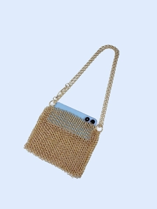 Golden handmade metal woven sequin crossbody phone bag with chain strap on blue background