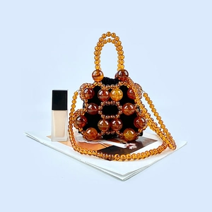 Detail of amber tortoiseshell beaded bucket bag with black drawstring inner liner