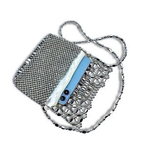 Detail of silver beaded shoulder bag with hollow flower pattern and internal zipper pouch