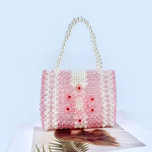 Détail du sac à main en perles acryliques roses et blanches avec motif floral brodé