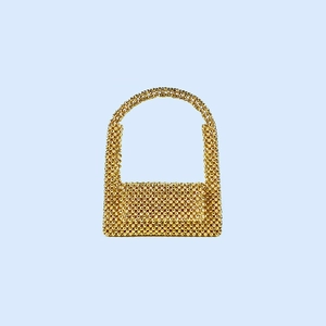 Gros plan de perles acryliques dorées montrant la texture tissée du sac à main chic