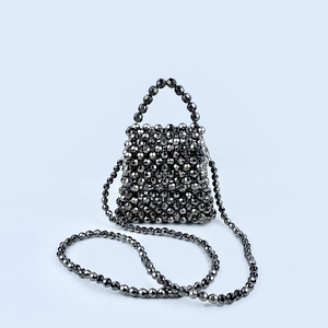 Detail of handmade woven bead bag in metallic gunmetal with faceted texture