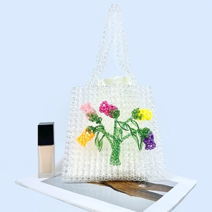 Detail of handmade acrylic beaded bag with colorful floral patterns and white satin liner