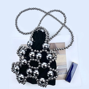 Detail of silver beaded floral shell handbag with a black velvet drawstring pouch inside