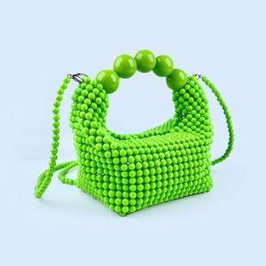 Detail of green handmade beaded handbag with large decorative beads on the handle