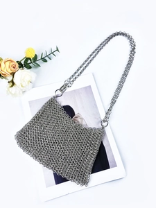 Silver chainmail crossbody bag with metal sequins and woven chain strap on white background