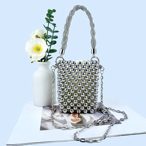 Close-up of silver beaded handbag showing handmade weaving and metallic chain strap