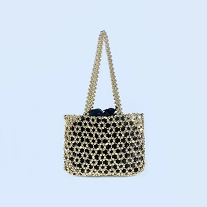 Detail of handcrafted gold beaded shoulder bag featuring a geometric mesh and inner drawstring bag