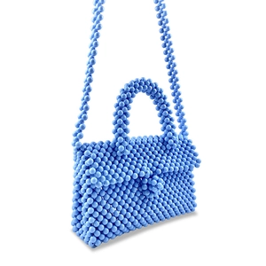 Detail view of light blue handmade beaded handbag with woven texture and matching shoulder strap