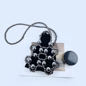 Macro view of silver beaded mini handbag with black velvet drawstring pouch and strap
