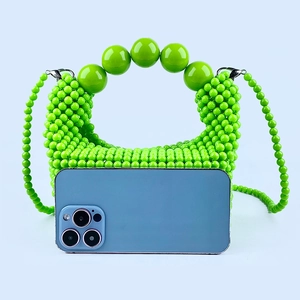 Mini green beaded handbag detail with handle and smartphone for size reference