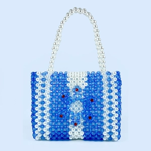 Détail du sac à main tissé main en perles acryliques avec motifs de fleurs bleues